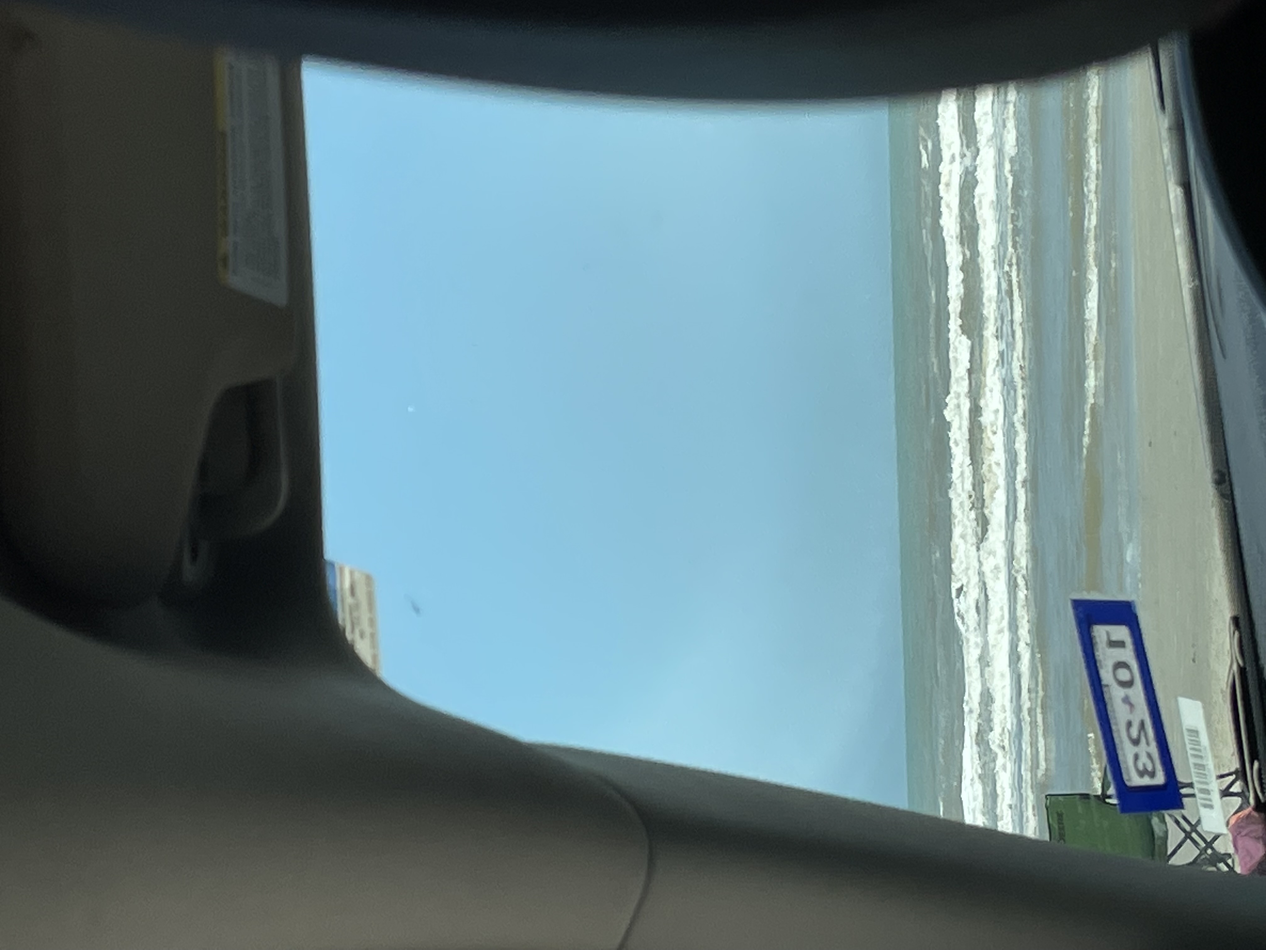 Image looking out of a car windshield to see a beach and the ocean
