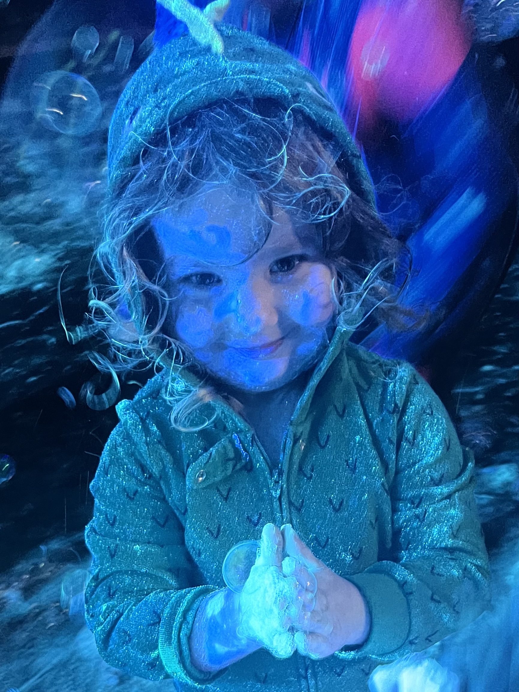 Young child covered in a fluorescent blue dust